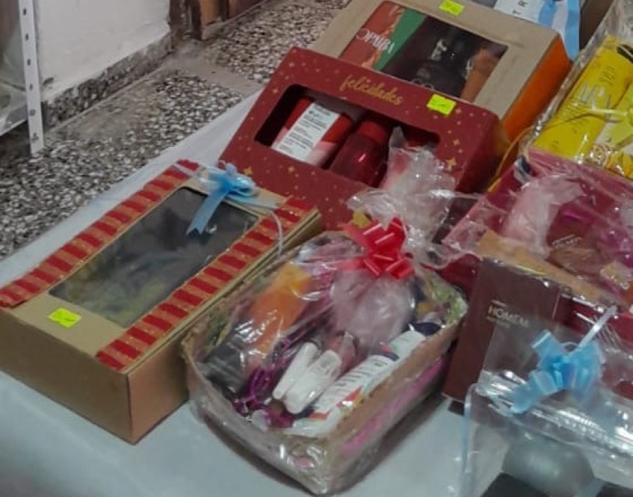 Mesa con combos de regalo armados a mano: cajas y canastas con moños, perfumes y productos de cuidado